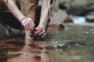 Doğal taş düzenlemeleri yapmak için kadın eli, nehirde denge taşları, bir denge bulmak için yönetim. Yönetim ve uyum kavramı.