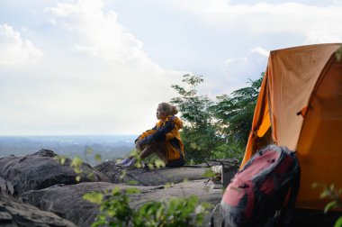 Kadın Gezginler Canlı Turuncu Çadırı Doğal Manzaralı Uçuruma Kuruyor. Cliff 'te Rahatlamak, Bakire Doğal Bakışları Kucaklamak ya da Uçurum Kenarı Güzelliği, Unutulmaz Kamp Yolculuğu ile Kuşatılmak.