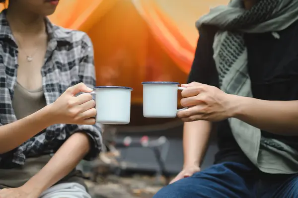 Close-up of Hand Holding Water Cups for Drink in the Forest. Campsite Drinking Coffee and Clean Water on Trekking Trips.