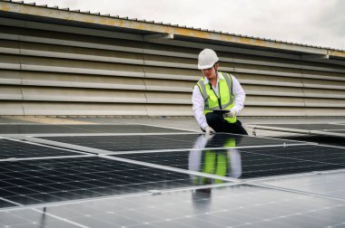 Mühendisler veya Uzman teknisyenler güneş fotovoltaik panellerinin kurulum kalitesini kontrol ediyor ve tabletlerdeki güneş panellerinden biriken enerji üretimini kontrol etmek için teknoloji uygulamaları kullanıyor.