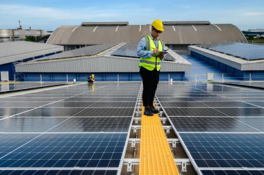 Mühendisler veya Uzman teknisyenler güneş fotovoltaik panellerinin kurulum kalitesini kontrol ediyor ve tabletlerdeki güneş panellerinden biriken enerji üretimini kontrol etmek için teknoloji uygulamaları kullanıyor.