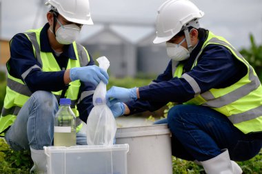 Çevre Mühendisleri Doğal Su Kaynakları 'ndaki kötü kokan su örneklerini şişeye koyup plastik poşetlere koydular. Zehirli Kirlilik Alanlarının Kirlettiği Suyu..