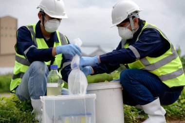 Çevre Mühendisleri Doğal Su Kaynakları 'ndaki kötü kokan su örneklerini şişeye koyup plastik poşetlere koydular. Zehirli Kirlilik Alanlarının Kirlettiği Suyu..