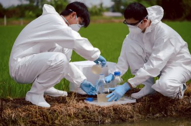 Fabrika bilim adamları veya biyologları tarım arazisi yakınlarındaki doğal su kaynaklarında su örnekleri toplarken koruyucu giysiler giyerler. Kimyasal koruma kavramı doğal su kaynaklarına sızabilir..