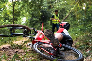 Dağ Bisikleti Kazası Bisikletçi Düştü ve Pratik Faaliyetlerde Yaralanma Doğal Park 'ta Bisiklet Sporu, İlk Yardım Personel Yardımcısından Acil Yardım.