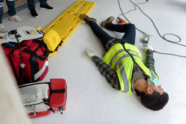 Work accident electric short circuit to a worker in the workplace and Unconscious lying on the floor after hand connecting power outlet to an electric tool with no electrical plug.
