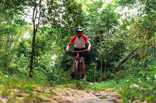 Extreme Mountain Biking, Cyclist ride on MTB trails in the Green Forest with Mountain Bike, Outdoor sports activity fun and enjoy riding. Basic techniques of the athlete.