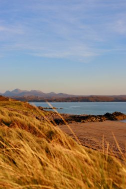 İskoç dağlarında gün batımı mavi okyanus ve arka planda dağlar