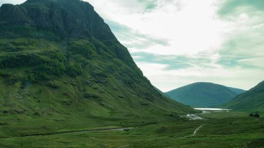 Güneşli bir yaz gününde dağın ve nehrin güzel manzarası