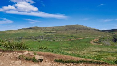 Dağları ve mavi gökyüzü olan güzel bir manzara.
