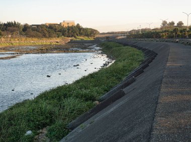 Parkta yeşil çimenleri olan güzel bir nehir görüntüsü.