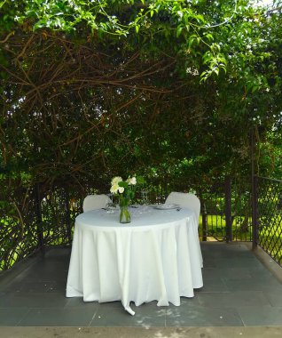 Bahçenin derinliklerinde iki kişilik romantik bir masa