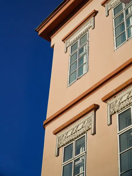 Pencereleri ve mavi gökyüzü olan eski tarihi binanın ön cephesi