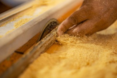 Yuvarlak testerenin yanındaki tahtayı tutan elleri kapatın.