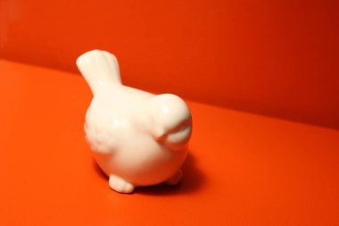 Turuncu arka planda beyaz porselen kuş ışık ve gölgenin sınırı.