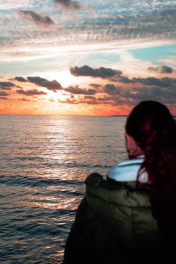 Kumsalda sırt çantalı genç bir kadın.