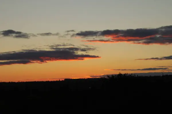 Gün batımı gökyüzünü canlı kırmızı, turuncu ve mor tonlarıyla doldurur..