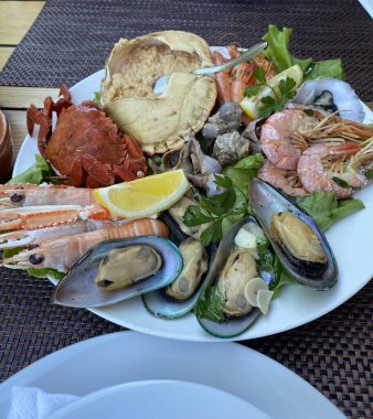 Bir tabak balık, deniz ürünleri, midyeler ve diğer yemekler..