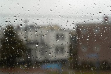  Bulanık bir zemin ile pencereye yağan yağmur, su damlacıklarının kadehten yavaşça aktığı hassas anı yakalıyor..