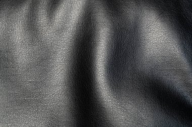 Parlak kaplamalı siyah sahte deri bir arka plan. Parlak, desenli sahte deri bir yüzey fotoğrafı. Bu kaliteli malzeme mobilya yapmak için mükemmel..