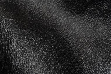 Siyah hakiki deri kaplamalı soyut bir arka plan. Fotoğrafta özgün derinin karmaşık ayrıntıları gösteriliyor. Derin kıvrımlar ve dokulu elementler var..