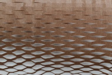 Bal peteği Kraft kağıdına yakın plan, eşsiz, çevre dostu yapısını gözler önüne seriyor. Doğal kahverengi doku, sürdürülebilir hediye paketleme, dayanıklılık ve çevresel sorumluluğu birleştirmek için ideal bir zemin sağlar..