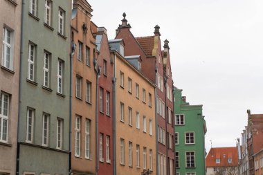 Gdansk 'taki Dlugi Targ Meydanı' ndaki renkli evler, her binada karmaşık mimari detaylar bulunan canlı bir sahne oluşturuyor. Birlikte, bu canlı cepheler meydanı göze çarpan bir yer haline getiriyor. Gdansk, Polonya - 3.11.2024.