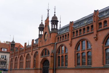 Gdansk, Polonya - 3.11.2024: Gdansk 'taki Dominik Pazar Salonunun cephesi gün ışığında yıkandı. Geniş ve görkemli, geleneksel Polonya mimarisi ve eski bir pazar yerinin ticari atmosferinin eşsiz bir karışımını sergiliyor..