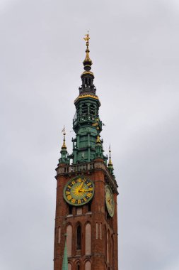 Ana Belediye Binası 'nın saat kulesine yakın çekim, Gotik ve Rönesans tasarımlarının çarpıcı bir örneği. Dluga Caddesi üzerinde yükselen bu yapı, yüzyıllar boyunca şehir tarihine tanıklık etmiş ve bir hükümet merkezi olarak hizmet vermiştir. Gdansk, Polonya, 3 Kasım 2024