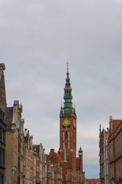 Bulutlu bir sonbahar gününde Gdansk 'ın ana kasaba salonunun atmosferik görüntüsü, gökyüzüne uzanan kule, şehrin zengin ortaçağ mirasını sembolize ediyor. Gdansk, Polonya - 3 Kasım 2024.