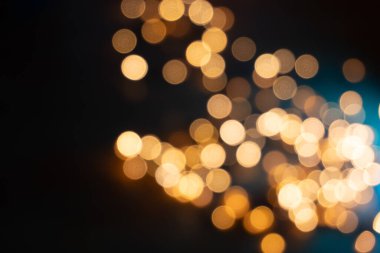 Noel çelenklerinin bokeh ışıklarına yakın çekim, parlak kürelerin yumuşak bulanıklığı büyüleyici bir etki yaratıyor.