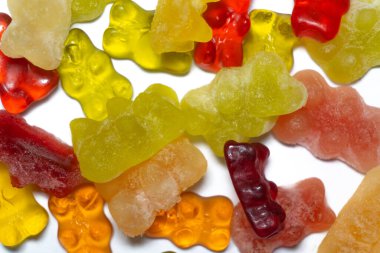 Donmuş ayıcıklar ve soda suyundan yapılan dondurulmuş şekerler, sosyal medya kullanıcılarının dikkatini çekerek sıradan şekeri yeni bir gastronomik keşfe dönüştürdü. Jelibon ayılar, beyaz arka planda sanatsal olarak kaotik bir düzende dağılmış durumdalar..