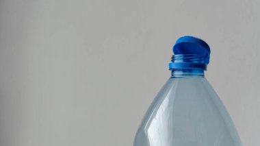 Modern kapaklı bir şişe: Şeffaf bir plastik şişe ve bağlı bir kapak, sıkıca kapatmayı ve rahatlığı sağlayan yenilikçi bir tasarım sergiliyor. Bu biçim ambalajı günlük kullanım için daha çevre dostu ve pratik hale getirir.