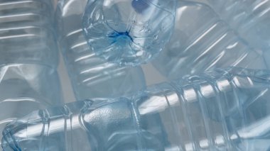 Kullanılmış boş PET şişeleri yığını bir araya getirilerek artan plastik atık sorununu vurguluyor. Bir zamanlar suyla dolu olan şişeler artık atılıp atılıyor ve çevreyi korumak için sorumlu imha ve geri dönüşüm ihtiyacını vurguluyor..