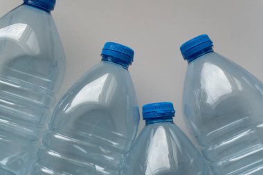 Düzensiz bir yığın boş PET şişesi, çöpe atıldı ve geri dönüştürülmeyi bekliyor. Bu yığın, plastik atıkların etkilerinin görsel bir temsili olarak hizmet vermektedir..