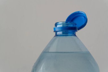 Bir şişe içme suyu: Plastiğin şeffaf yapısı sıvının saflığını vurgular, ambalajın işlevselliğini ve uygulanabilirliğini vurgular.