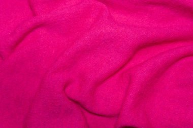 Parlak pembe yün kumaş: canlı pembe renkli, dalgalı bir yün dokusu. Parlak pembe yün kumaşın dinamik çizgileri maddeye enerji ve modern bir his katar..