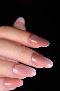 Şeftali rengi bir manyetik manikürün detaylı görüntüsü, parlak önlük, metalik etkiyi vurguluyor ve 