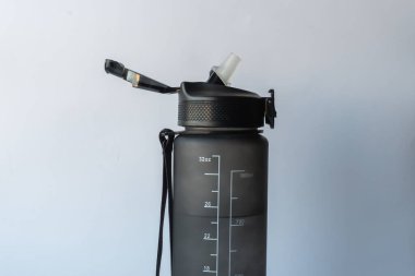 Her yudumda tazelik açık bir başlığı ve ölçü terazisi olan bir su şişesi. Susuzluğun önemini hatırlatan bir şey. Açık başlıklı siyah su şişesi ve güvenli, desenli bir kapağı var..