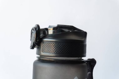 Pürüzsüz bir tasarım. Kapağı sıkıca kapatılmış siyah bir su şişesi. Minimalizm ve işlevsellik bir aksesuarda. Kalıplı kavrama, kullanım kolaylığı sağlar.