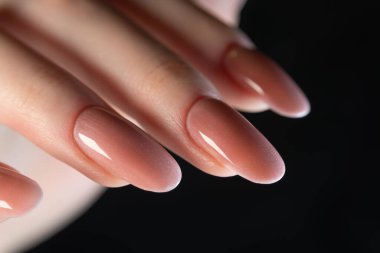 Oval şekilli uzun tırnaklı zarif manikür ve parlak bir 