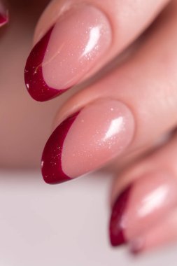 Pırıl pırıl parlayan koyu bordo Fransız uçları, beyaz bir arka plan üzerinde lüks ve tutku etkisi yaratıyor. Bordo ipuçlarının parlak bir sonu ve ince bir parıltısı var..