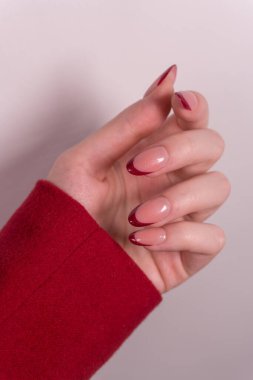Yumuşak bordo manikürlü Fransız manikürlü sessiz koyu uçlar daha kısıtlı ve zarif bir görünüm sunuyor, tat ve bireyselliği vurguluyor..