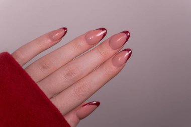 Parlak kırmızı Fransız manikürü Pürüzsüz, parlak uçlar bakımlı ellerin altını çiz ve cesur bir açıklama yap. Zarif bir Fransız manikür tarzında parlak kırmızı uçlu tırnakları olan bakımlı bir el.. 