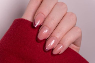 Klasik kırmızı Fransız manikürü, bej tabanlı parlak kırmızı uçlar genel modele kadınlığı, tutkuyu ve güveni ekler. Zamansız bir manikür seçimi.