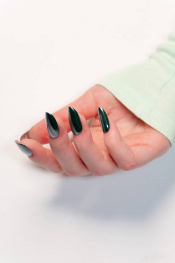 Geniş parmaklı koyu yeşil bir manikür renk ve şekle değer verenler için çok yönlü ve modaya uygun bir seçim..