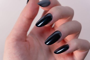 Beyaz bir zemin üzerinde açık ve rafine siyah manikür kontrastın şekli ve parlaklık algısını arttırır..