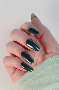 Beyaz arka planda koyu yeşil jel tırnaklar. Minimalist zarafet, zengin renk derinliğiyle buluşur. Şenlikli ve şık bir görünüş için mükemmeldir..