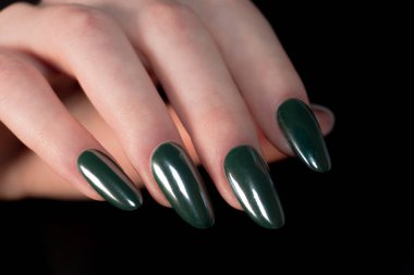 Siyah arka plandaki zengin orman yeşili manikür kontrastın rengin canlılığını ve çivi şeklinin hassasiyetini yoğunlaştırır..