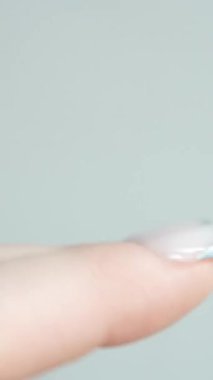 Işıldayan gümüş uçlu Fransız manikürü göze çarpan makro bir çekim, parlak Fransız kenarı ile mat tabanı arasındaki kontrastı vurgular. Manikür stüdyo ışıkları altında çok çarpıcı görünüyor..